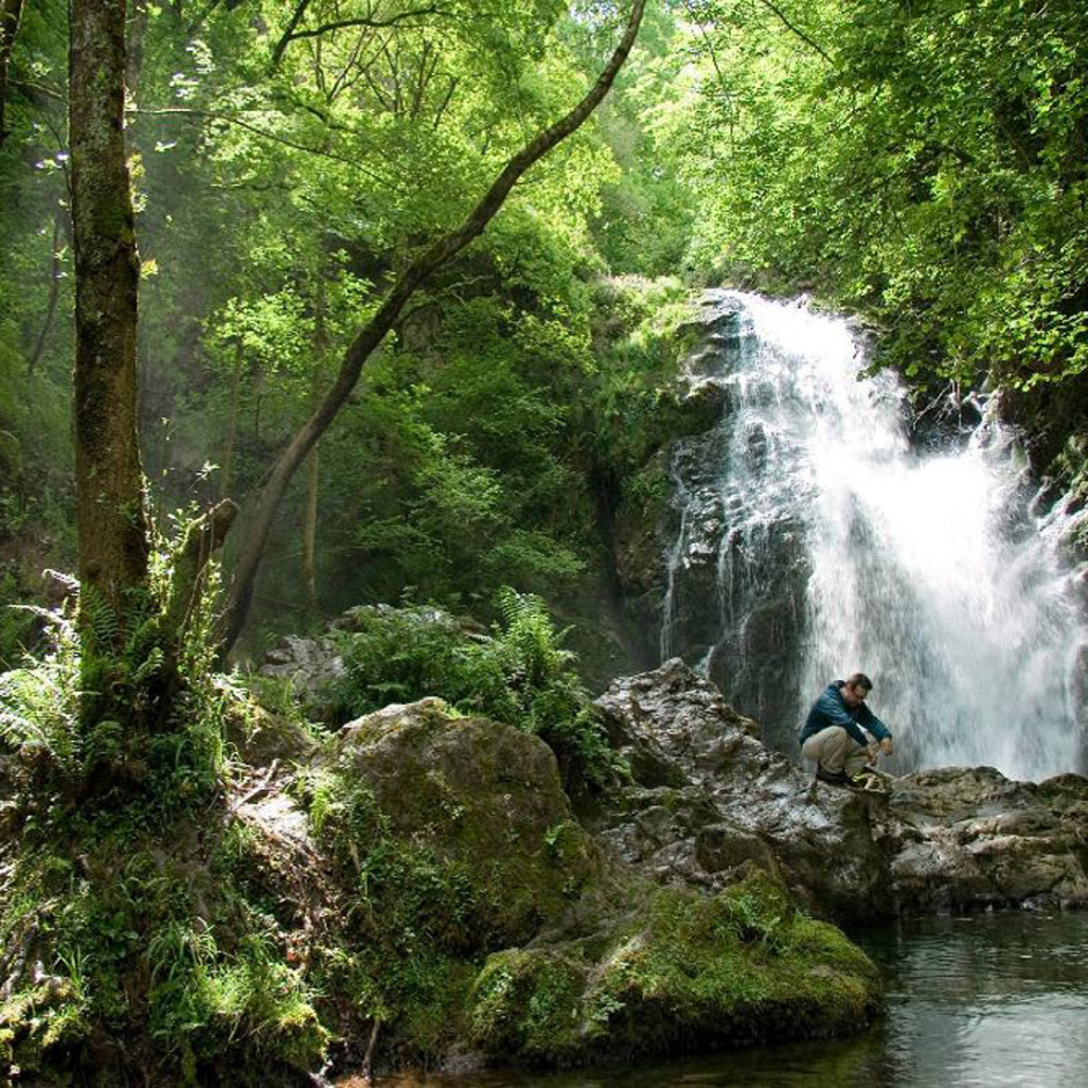 Cascada de Xorroxin con senderista sobre las rocas