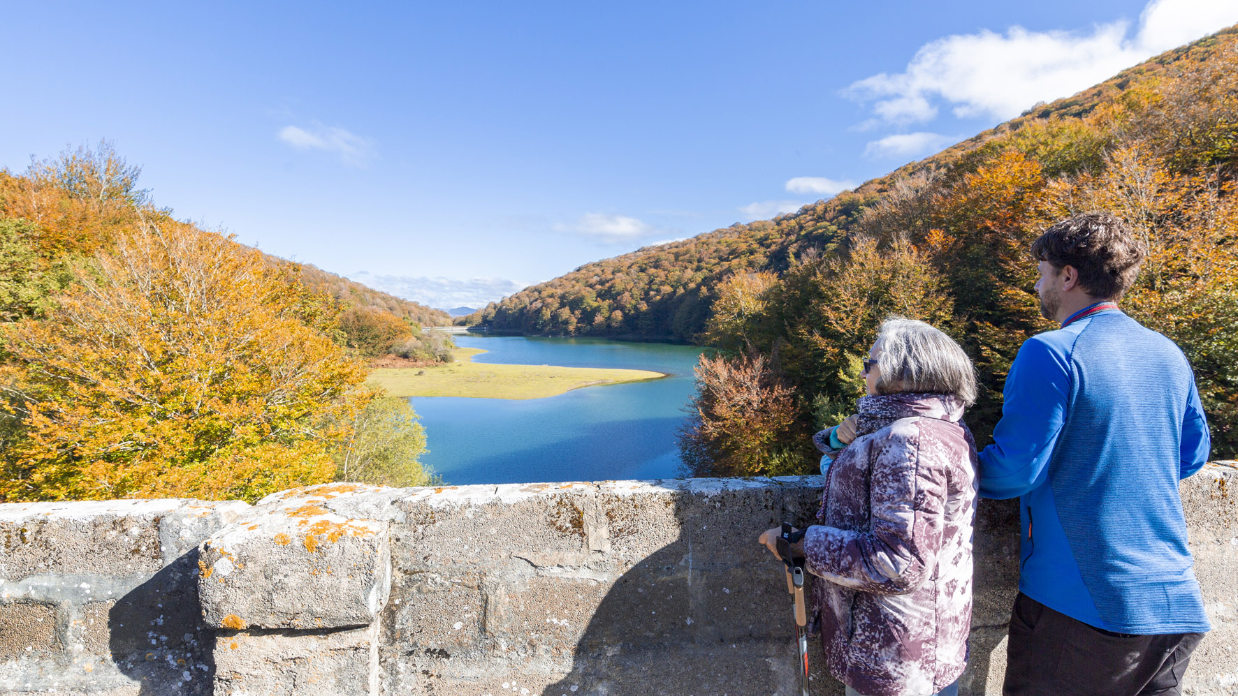 una mujer y un joven en la presa mirando el embalse