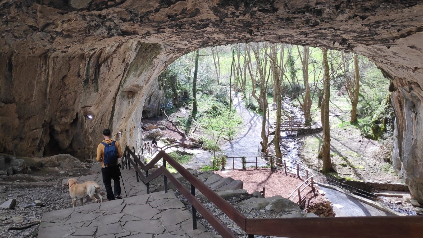 una pesona con un perro en la cueva de Zugarramurdi