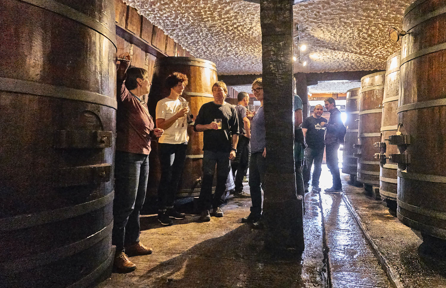 Boire du cidre en groupe dans une cave