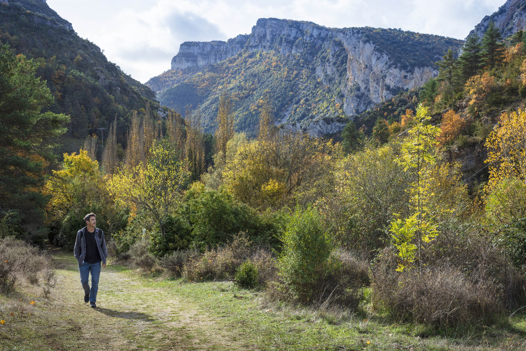 hombre andando por un camino y al fondo montes