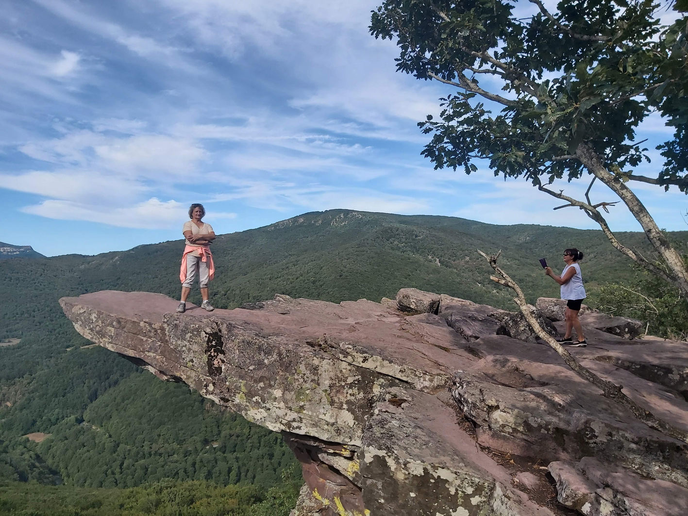 un mujer en la roca del mirador y otra sacándole una foto