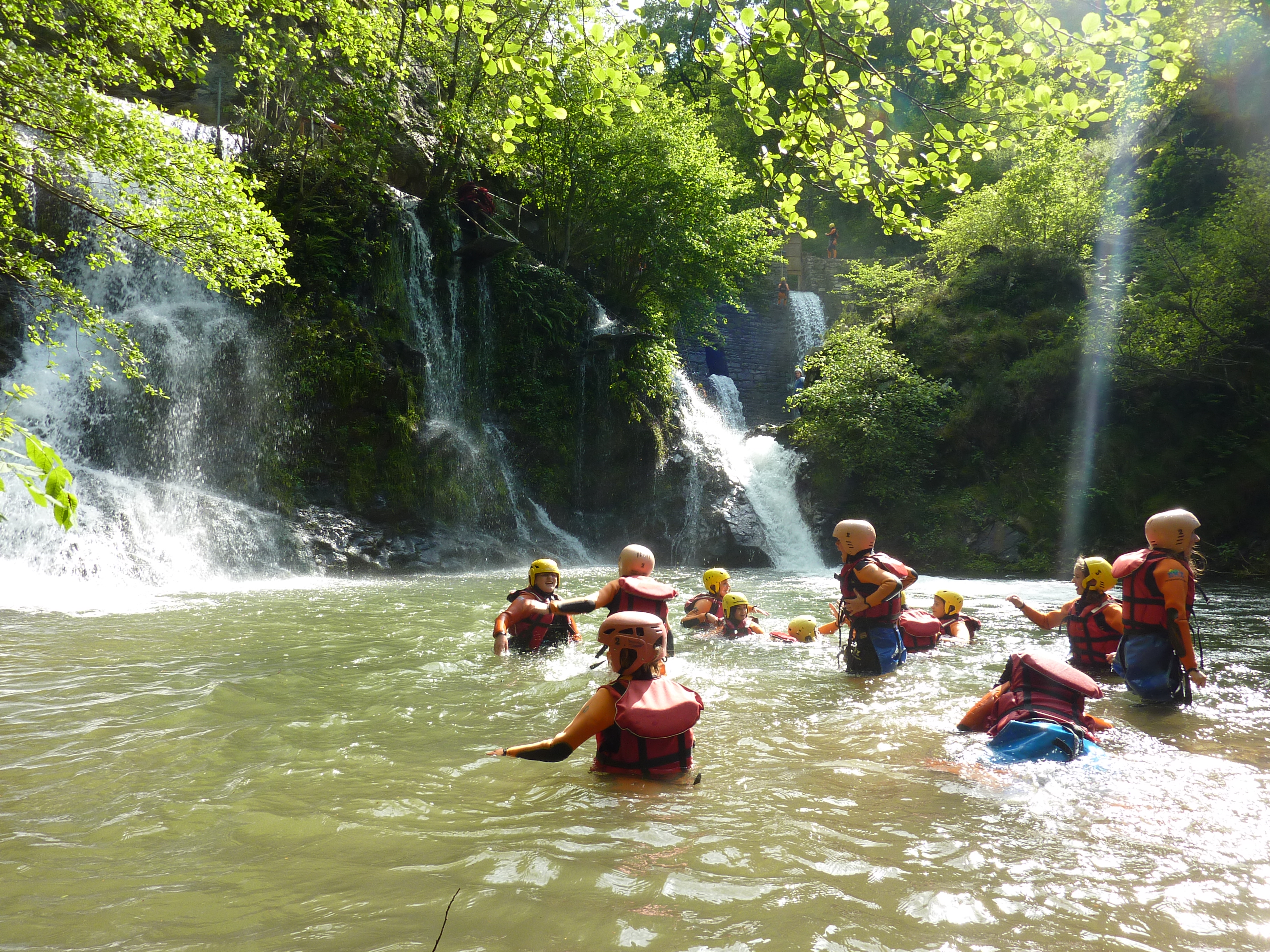 grupo de adolescentes en el río con chalecos y casco