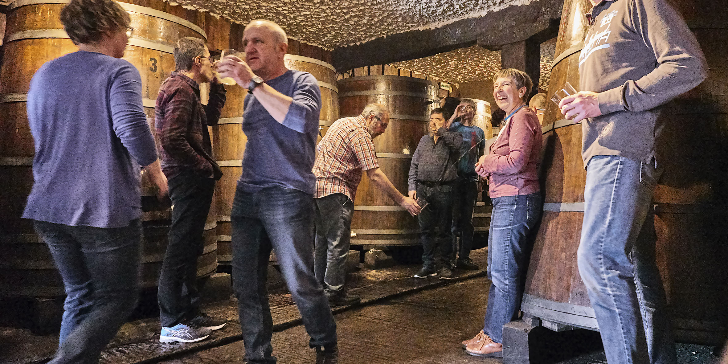 grupo de personas en la zona de kupelas de la sidrería hablando y bebiendo sidra