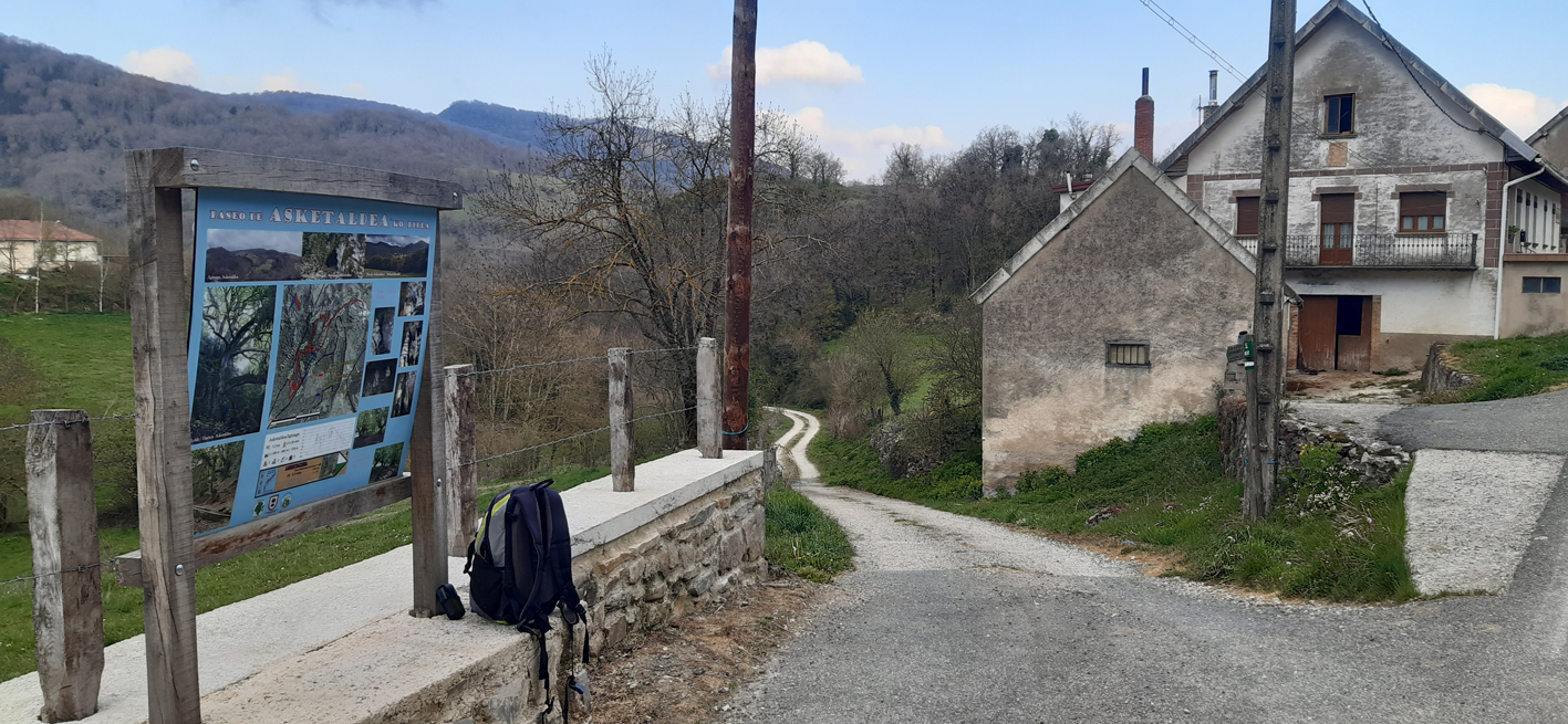 panel del sendero y casas al fondo