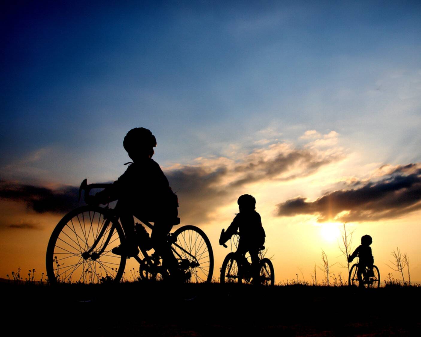 Children cycling at sunset
