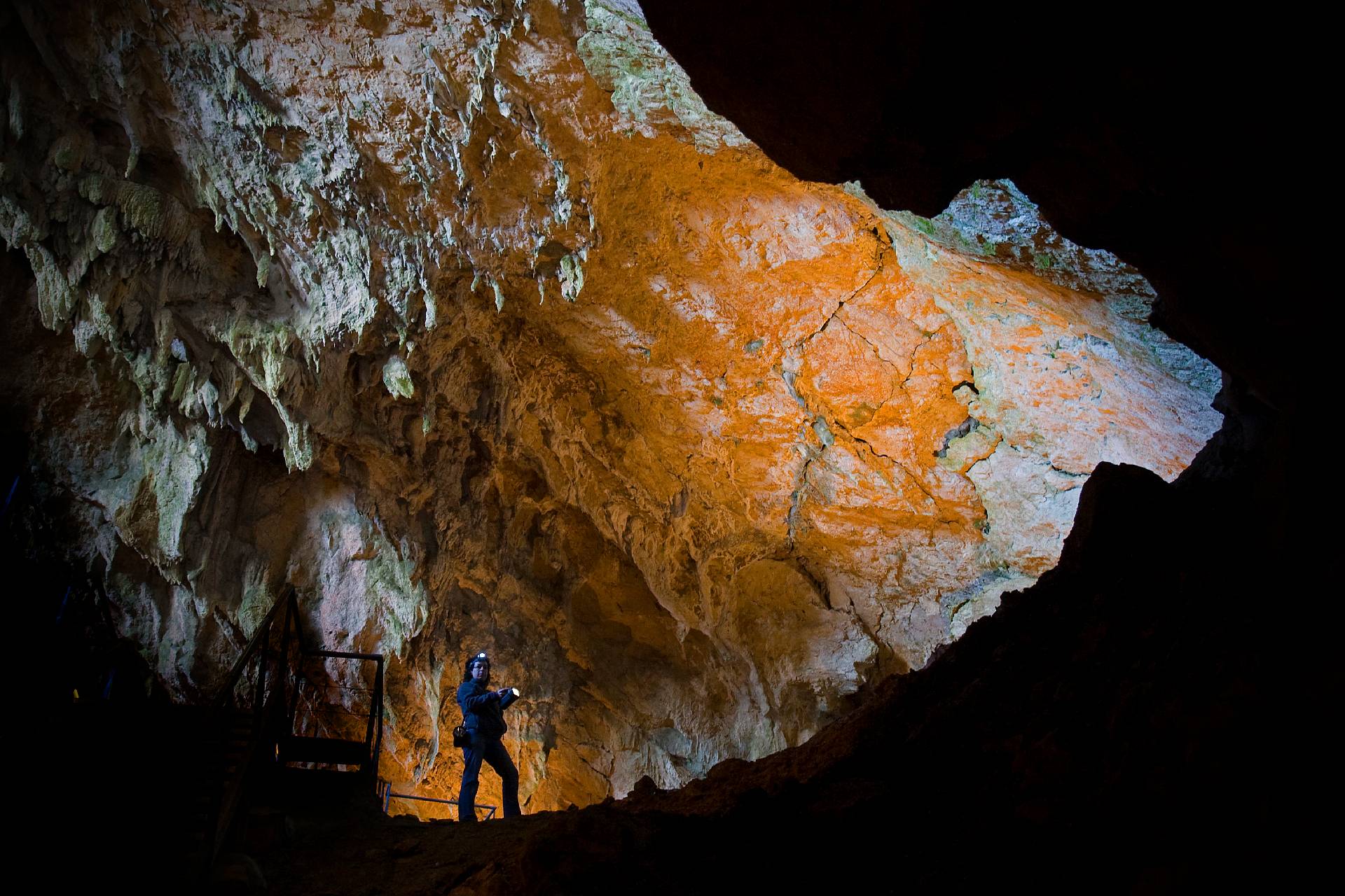 Fille avec une lampe de poche dans la grotte de Mendukilo