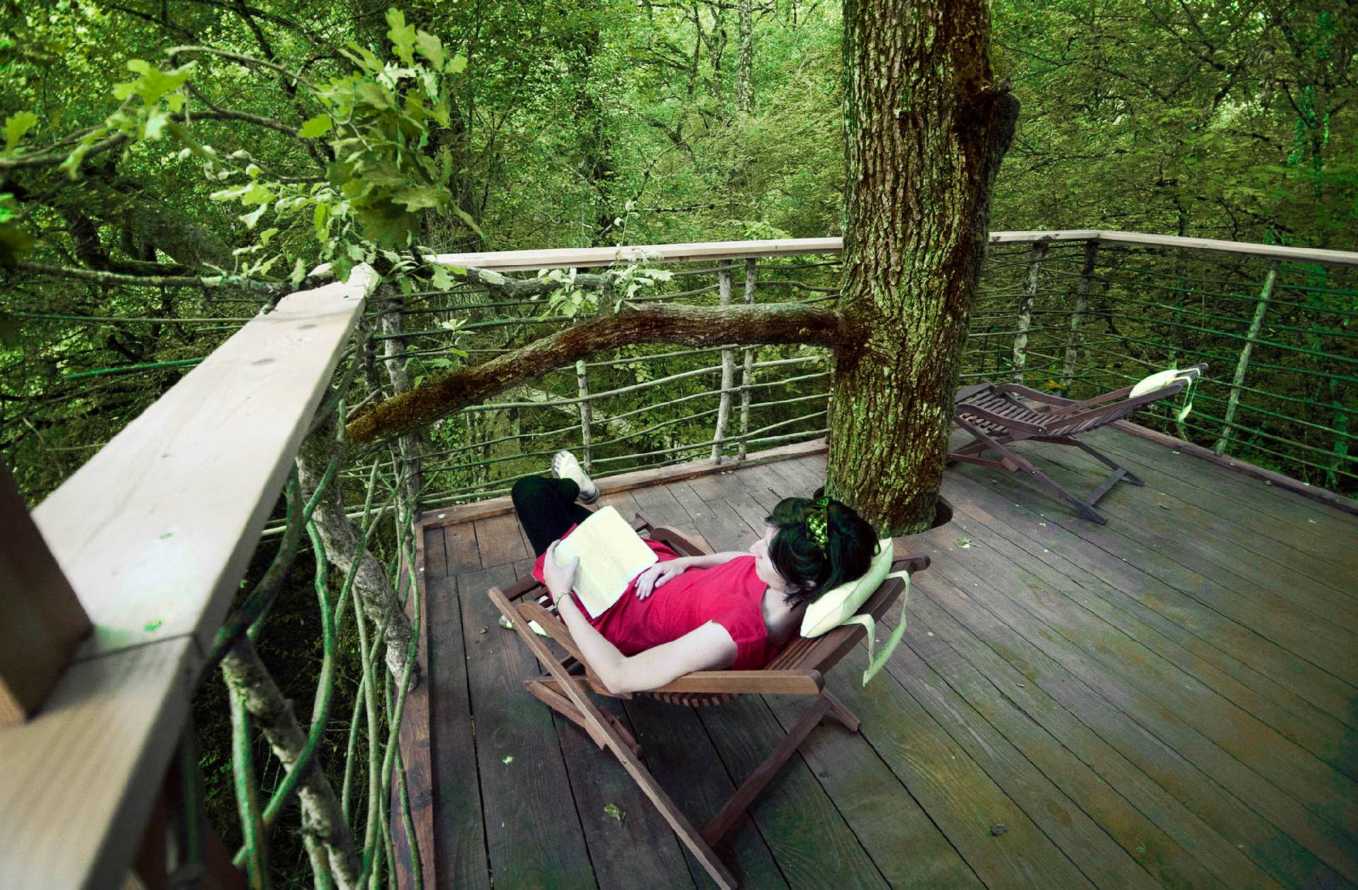 Girl reading in the hammock in a tree house