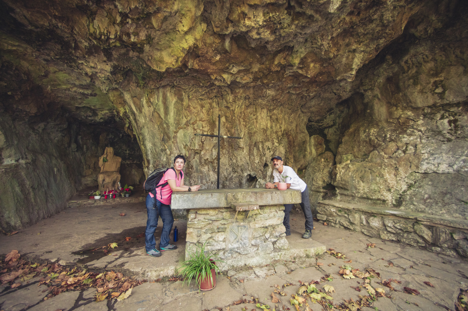 un hombre y una mujer apoyados en un altar de piedra