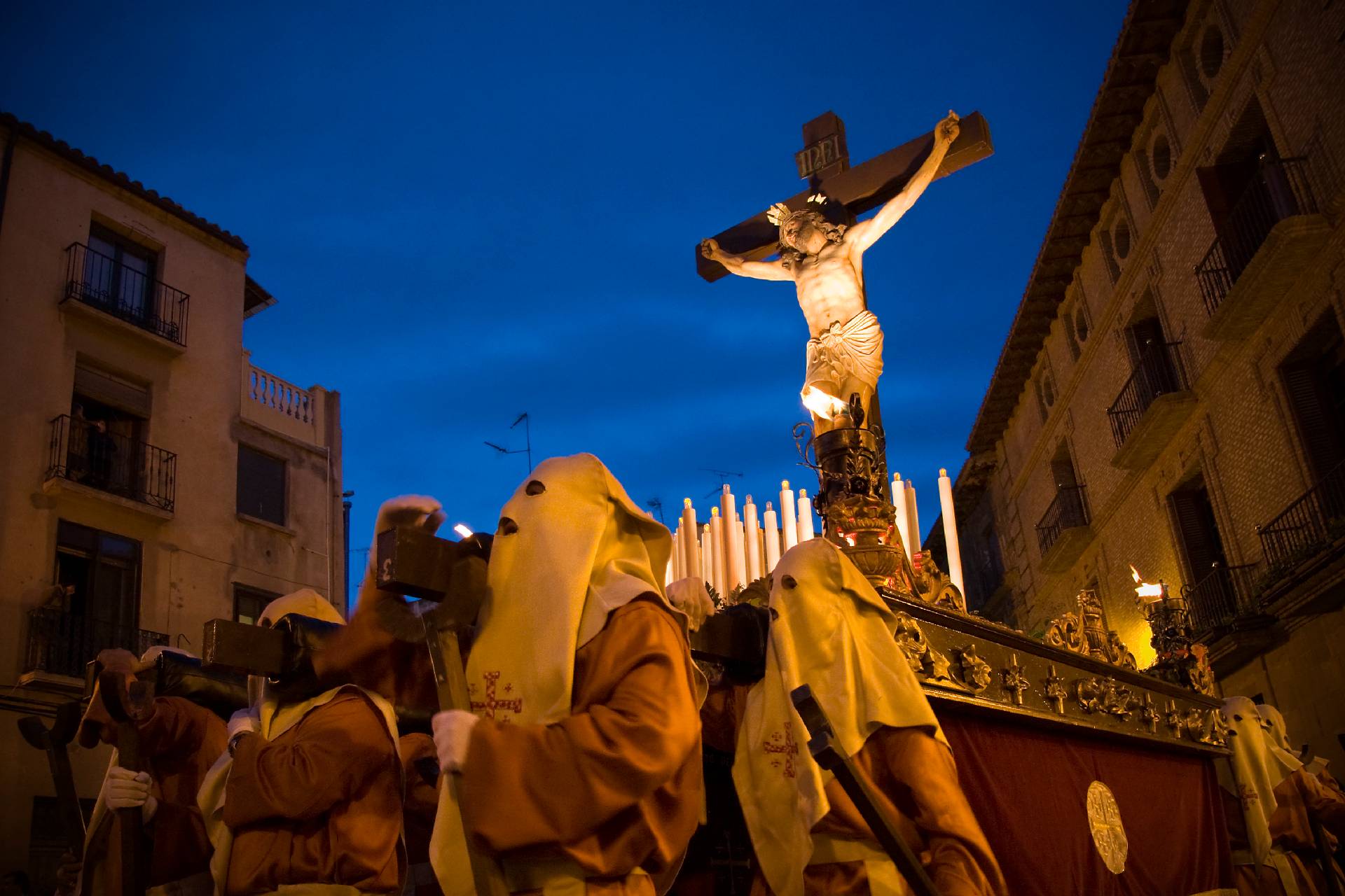 Holy Week procession at dusk with Christ on the cross and Nazarenes