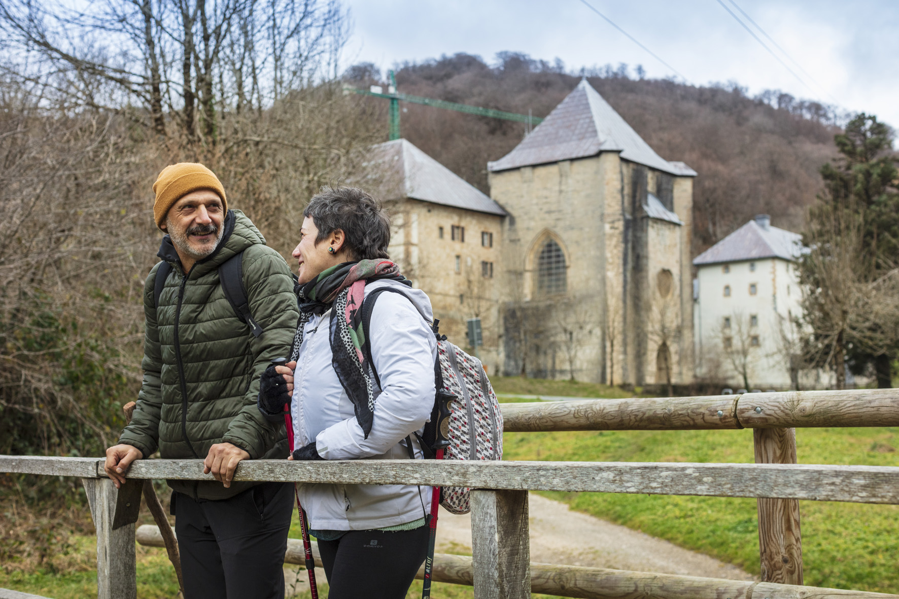 pareja apoyados en una valla de madera y al fondo Roncesvalles
