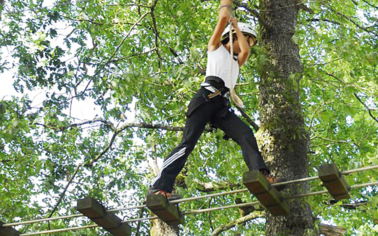 Girl practicing arborism at the Artamendia Adventure Park