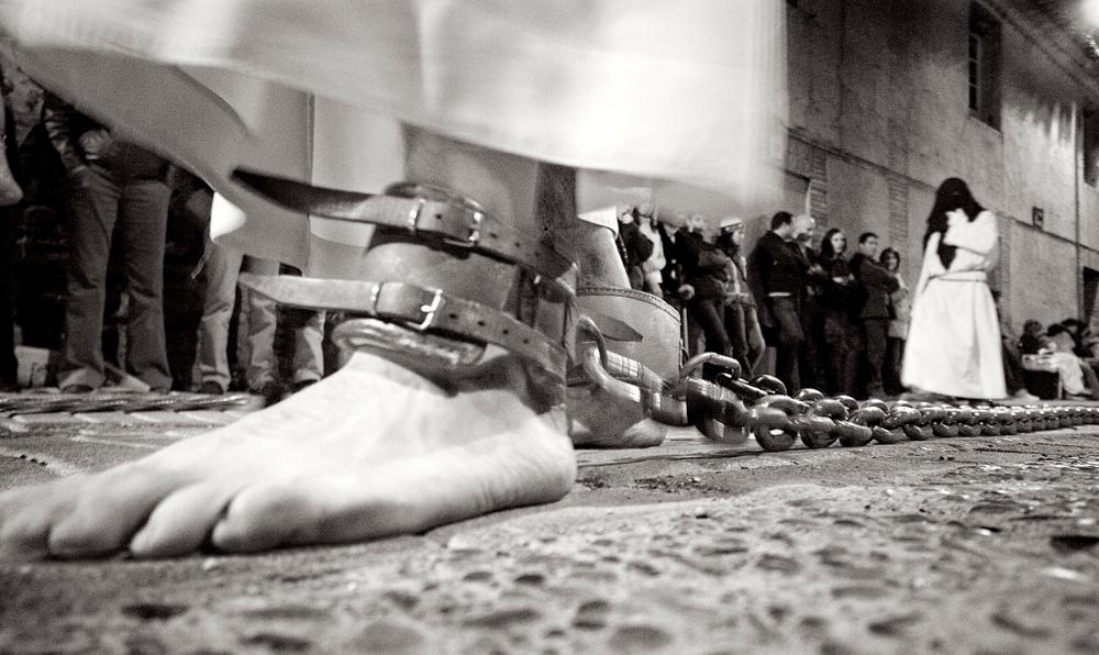 Fotografía en blanco y negro de los pies encadenados de un penitente
