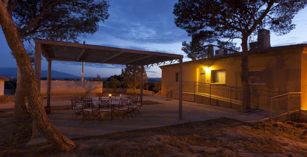 Porche avec table et chaises autour devant une maison au rez-de-chaussée avec une rampe pour y accéder