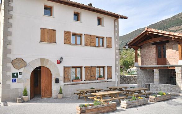 Facade of the Gure Sustraiak hostel, a traditional white farmhouse with wooden shutters