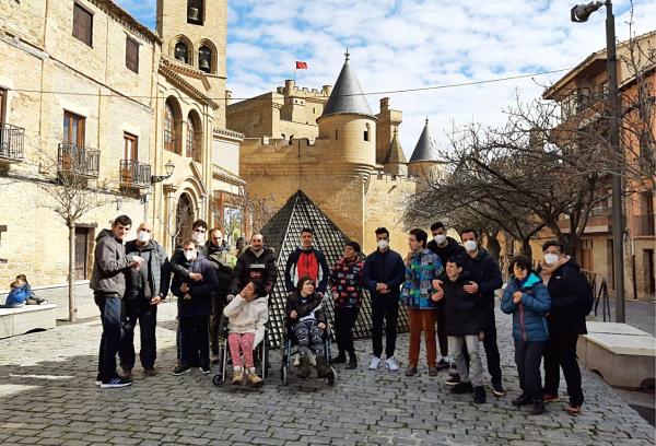 Groupe de personnes handicapées cognitives sur la Plaza de Carlos III devant le château d'Olite