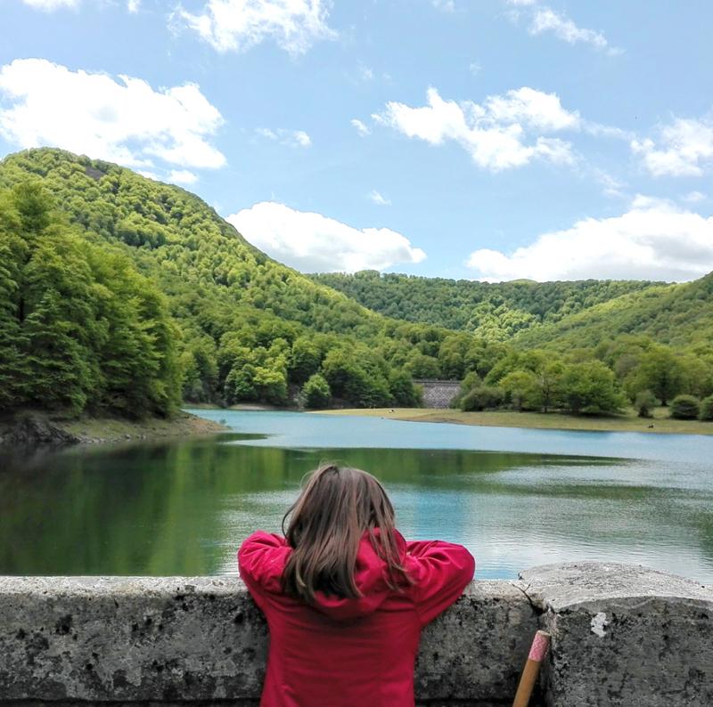 Niña de espaldas mirando el embalse