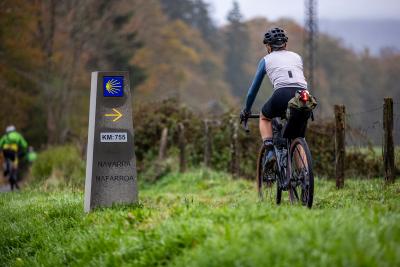 Ciclista al lado de una señal del Camino de Santiago