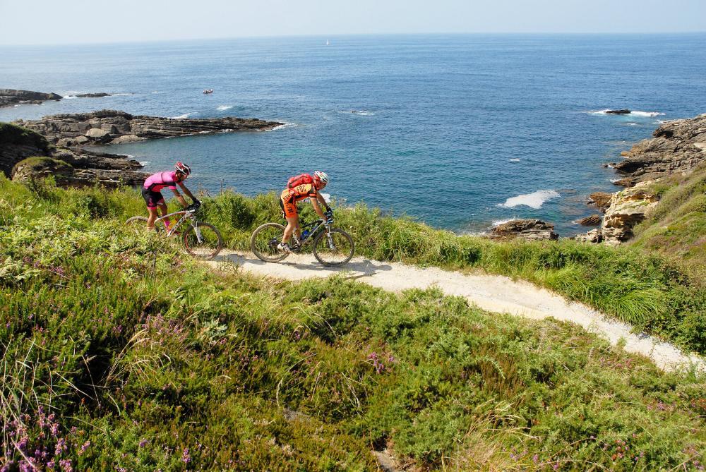 Dos ciclistas y al fondo el mar