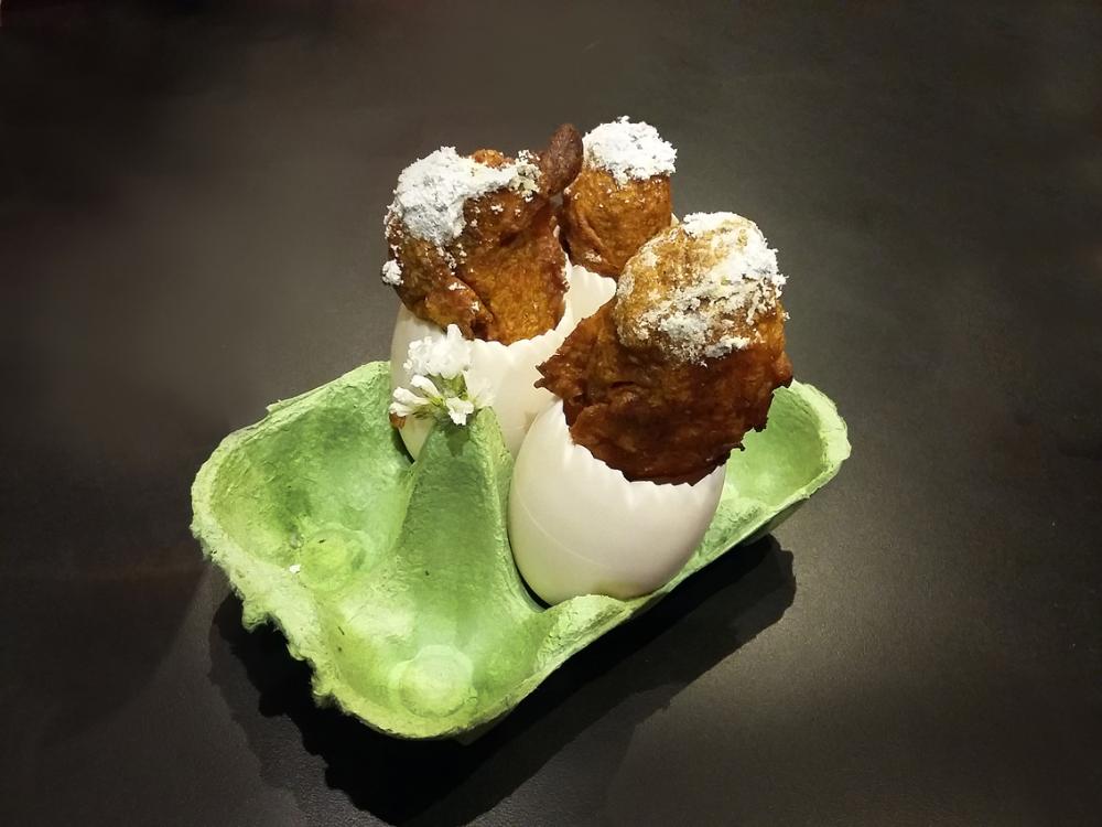 pincho elaborado, parece una cascara de huevo blanco en una huevera de catrón