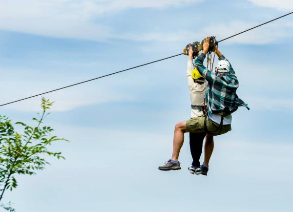 A couple descends by zip line in Irisarri Land