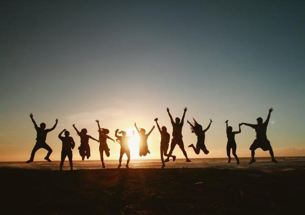 Groupe sautant sur une plage au coucher du soleil