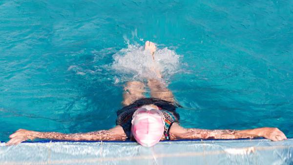 Mujer relajándose en la piscina de un balneario
