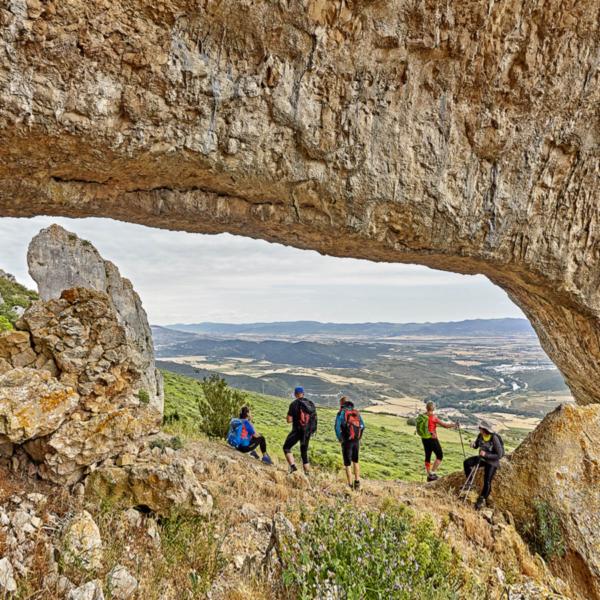 Hikers contemplating the landscape from the eyes of Lumbier